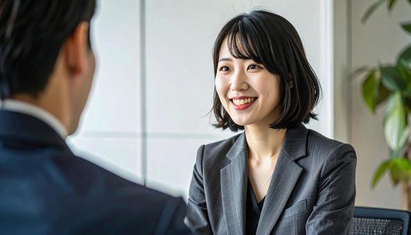 笑顔で話すスーツ姿の女性の写真