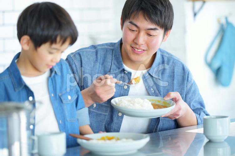 笑顔でカレーを食べる男性 親子,男の子,食べ物の写真素材