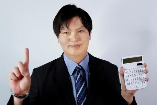 計算機を持つビジネスマン 計算機を持つビジネスマン ビジネスマン,男性,計算機の写真素材