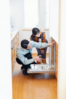 業者にキッチンをみてもらう主婦 業者にキッチンをみてもらう主婦 リノベーション,メンテナンス,トラブルの写真素材