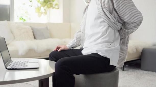 パソコン作業で腰が痛くなるアジア人男性 パソコン作業で腰が痛くなるアジア人男性 タイピング,腰,痛いの写真素材