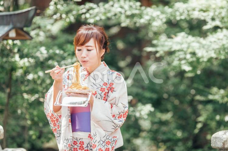 夏祭りで焼きそばを食べる浴衣姿の女性 焼きそば,縁日,夏祭りの写真素材