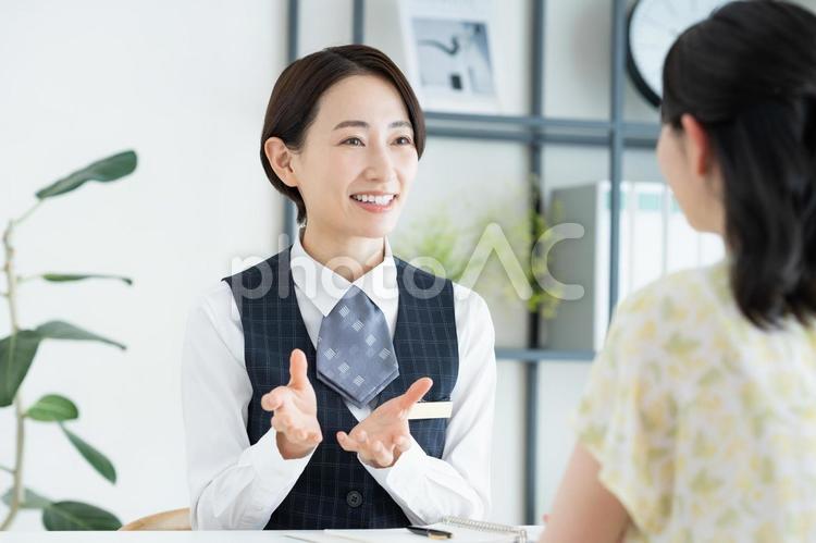 若い女性に説明するビジネスウーマン カウンセリング,相談,受付の写真素材