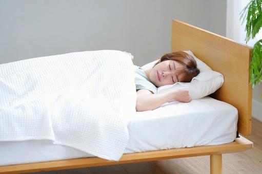 ベッドで睡眠中の女性の写真