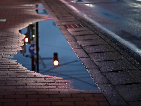 歩道の水溜まりに映る赤信号 歩道の水溜まりに映る赤信号 夜景,歩道,リフレクションの写真素材