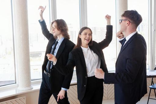 窓際で踊る楽しそうな男女 男女,外国人,ビジネスの写真素材