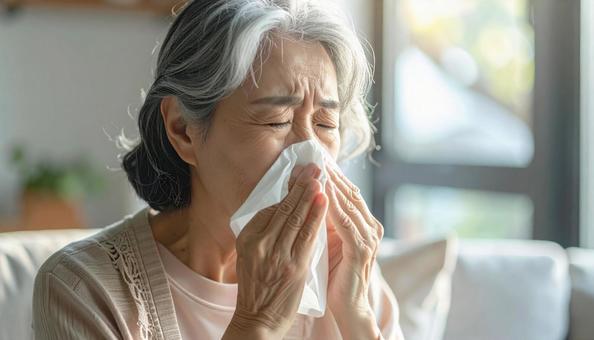 ティッシュで鼻をかむ日本人のシニア女性 ティッシュで鼻をかむ日本人のシニア女性の写真