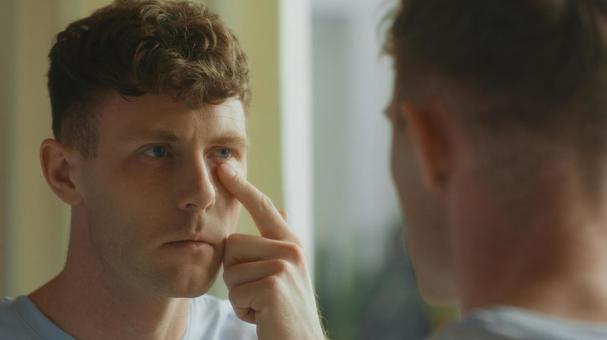 洗面所の鏡で目元を触る男性 男性,外国人,欧米人の写真素材