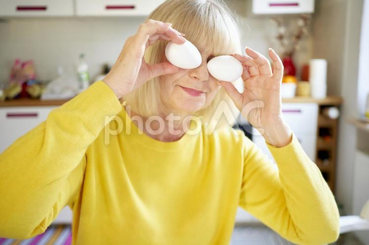 卵を目に当ててお茶目な女性 女性,卵,目の写真素材