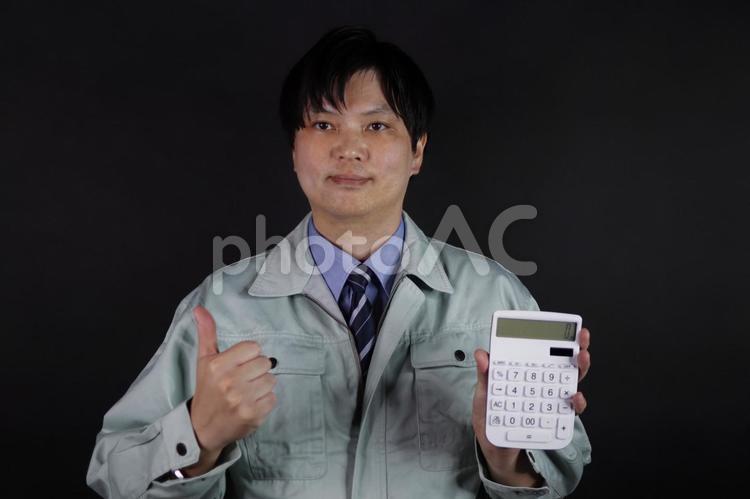 作業服の男性が電卓と親指を立てる 作業員,作業服,男性の写真素材