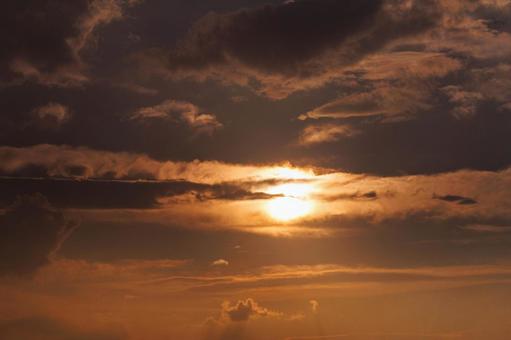雲の隙間から見える夕日 雲の隙間から見える夕日の写真