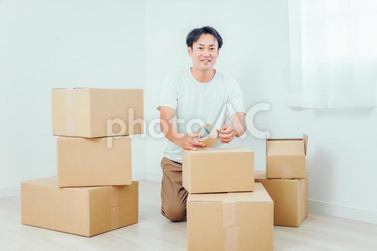 荷造りする男性（笑顔） 荷造り,引越し,ダンボールの写真素材
