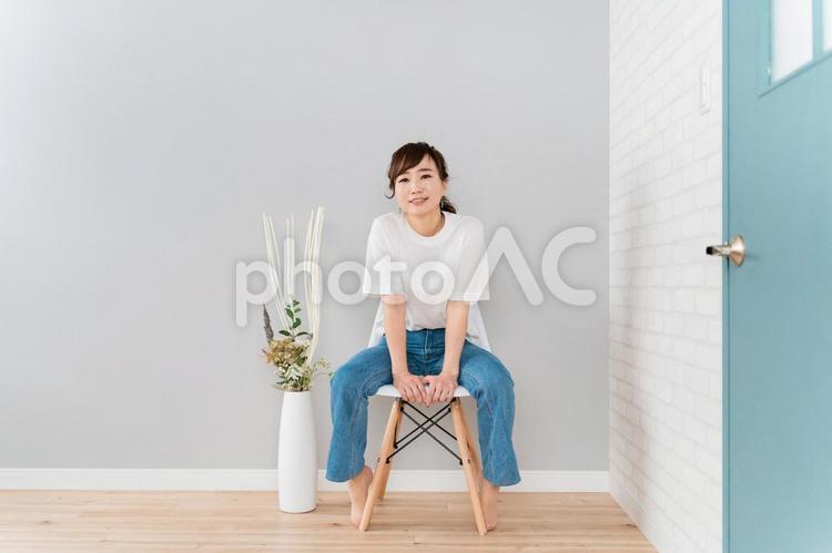 家で椅子に座るジーンズ姿のアジア人女性 椅子,女性,新生活の写真素材