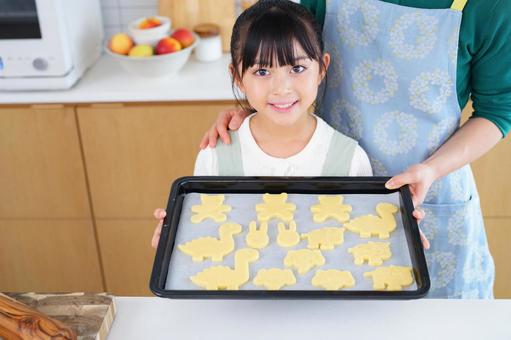 手作りクッキーを見せるエプロン姿の女の子 女の子,日本人,クッキーの写真素材