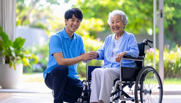 車椅子に乗った高齢女性と男性介護士 車椅子に乗った高齢女性と男性介護士の写真