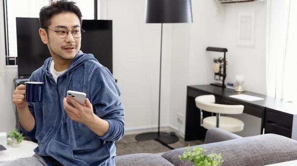 コーヒーを飲みながらスマホを使う男性 コーヒーを飲みながらスマホを使う男性 男性,人物,日本人の写真素材