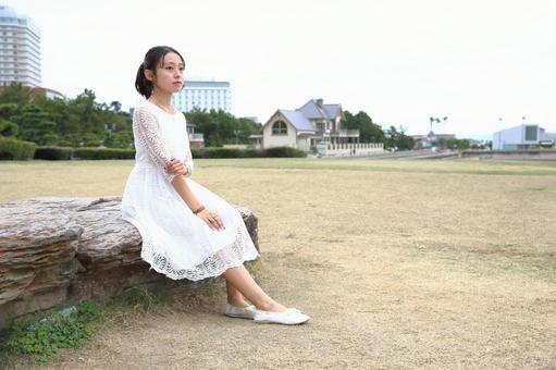 広場に座り遠くを見る女性 座る,女性,広場の写真素材