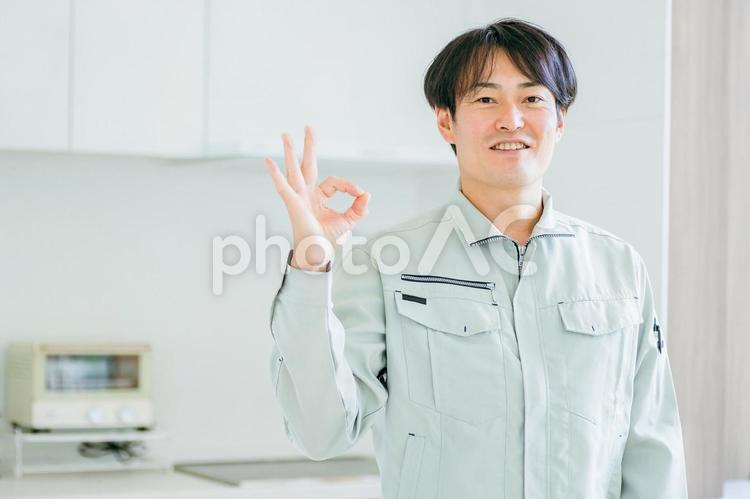 キッチンと作業着姿の男性（カメラ目線） 工務店,作業服,設備の写真素材