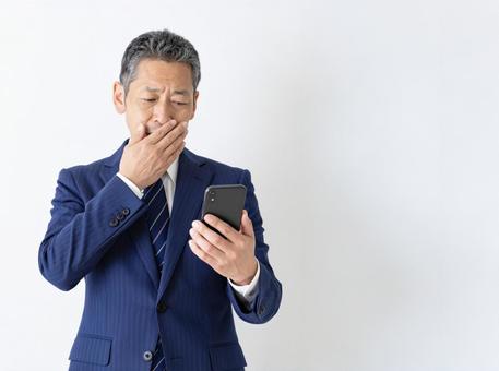 スマホ 50代 笑顔 悪い知らせ の写真