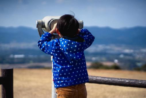 <人物>山の上で双眼鏡を覗く男の子 <人物>山の上で双眼鏡を覗く男の子 子供,双眼鏡,空の写真素材