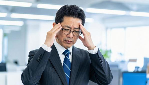 ビジネスイメージ　頭を抱えるビジネスマンの写真