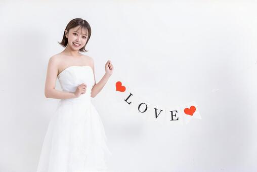 ハートのオーナメントを持つ女の子 ウェディングドレス,結婚式,花嫁の写真素材
