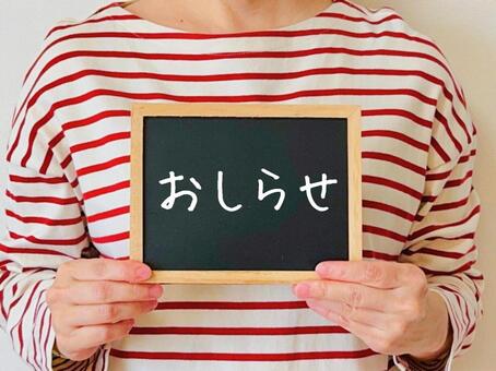 おしらせと書かれた黒板を持つ女性 おしらせ,女性,告知の写真素材