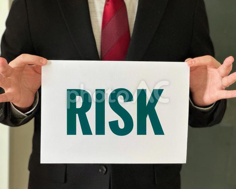 リスクと書いてある紙を持つビジネスマン ビジネス,リスク,riskの写真素材