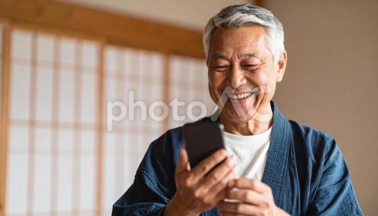 和室でスマホを見て笑顔の高齢日本人男性 人物,男性,日本人の写真素材