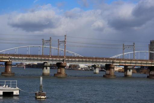 鉄橋と川と雲と青空と街並みの風景 鉄橋,川,雲の写真素材