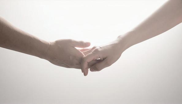 手を取り合う男女の写真