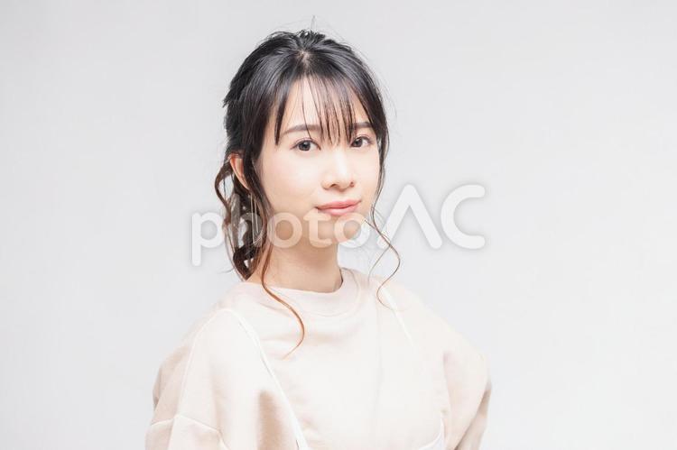 白い背景の前に立ってポーズをとる若い女性 女性,白背景,立つの写真素材