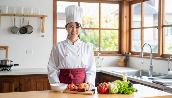 レストランの調理場で料理するスタッフ女性 レストランの調理場で料理するスタッフ女性の写真