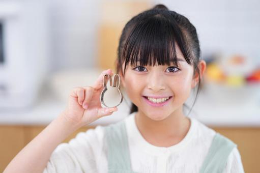 生地を前にお菓子作りを楽しむエプロン姿の少女 女の子,日本人,型抜きの写真素材