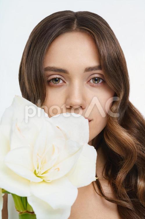 白い大きな花とカメラ目線の女性 女性,花,アマリリスの写真素材