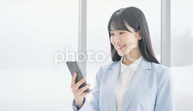 スマホを確認するビジネス女性 ビジネスマン,会社員,社会人の写真素材