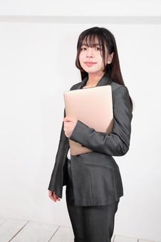 パソコンを持つ女性 パソコンを持つ女性 女性,パンツスーツ,人物の写真素材