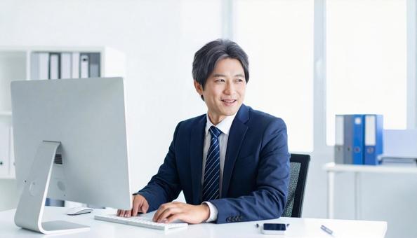 オフィスでパソコン使用した仕事をする男性 オフィスでパソコン使用した仕事をする男性の写真