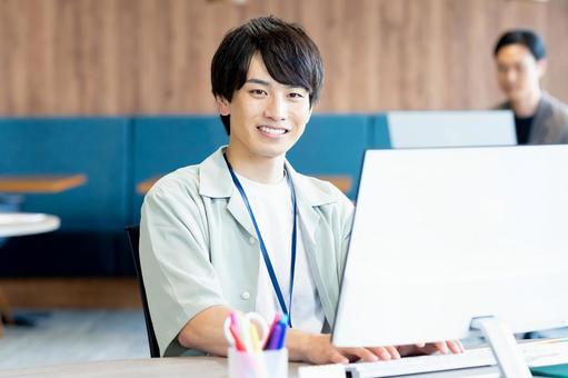 オフィスで働く若いビジネスマン オフィスで働く若いビジネスマンの写真