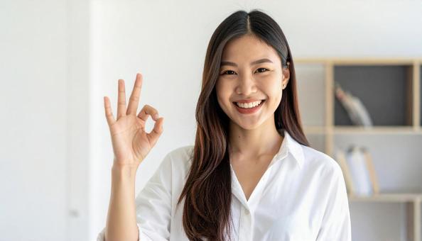笑顔でOKサインをする女性のポートレートの写真