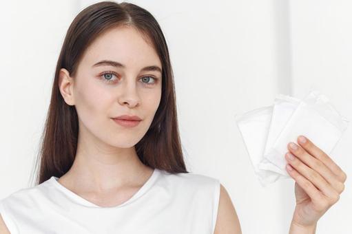 生理用ナプキンを持って微笑む女性 生理,月経,女性の写真素材