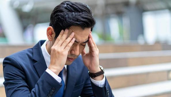 頭を抱えるビジネスマン 頭を抱えるビジネスマンの写真