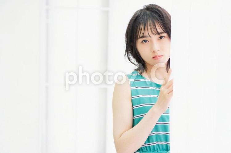 窓際に立ってこちらを見つめている若い女性 窓際,立つ,若いの写真素材