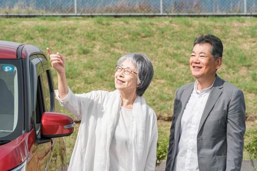 駐車場で休憩をするシニア夫婦（ドライブ） ドライブ,高齢者,旅行の写真素材