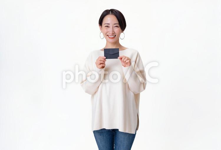 招待状を持つ私服の女性 通知,一人,透明感の写真素材