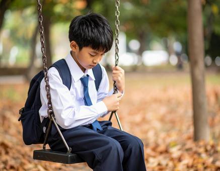 ブランコに座りうつむく男子中学生の憂い ブランコに座りうつむく男子中学生の憂いの写真