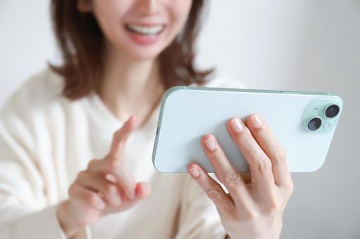スマホで動画を見る女性 スマホ,スマートフォン,女性の写真素材