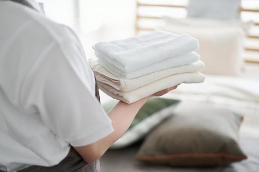 Asian woman folding towels and putting them away, laundry, fold, bed making, JPG