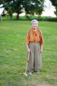 微笑み芝生でスティックを持つおばあちゃん 女性,スティック,持つの写真素材