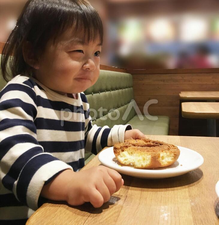 ドーナツを食べてニヤニヤする子供 ドーナツ,ニヤニヤ,にやにやの写真素材